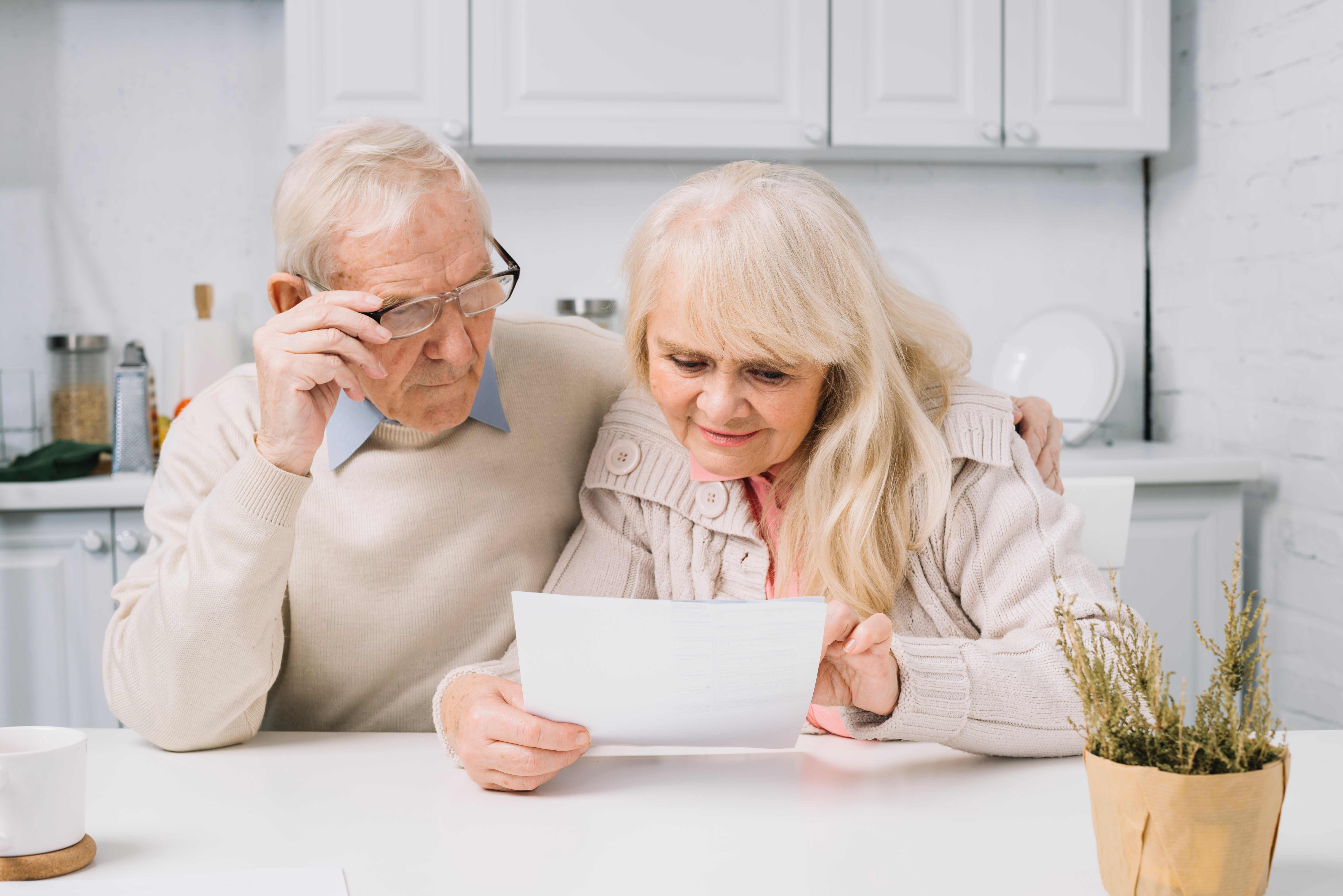 Senior couple reviewing healthcare documents and paperwork together